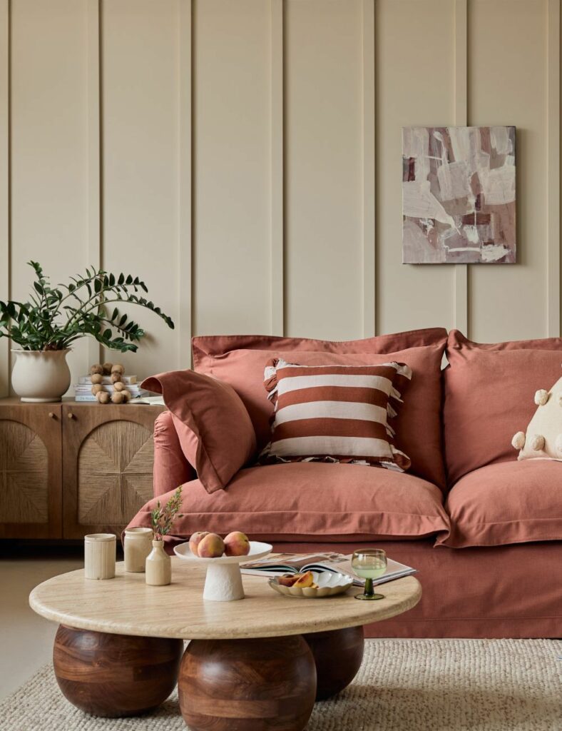 Canapé en coton avec coussins à motifs et tapis texturé dans un salon chaleureux