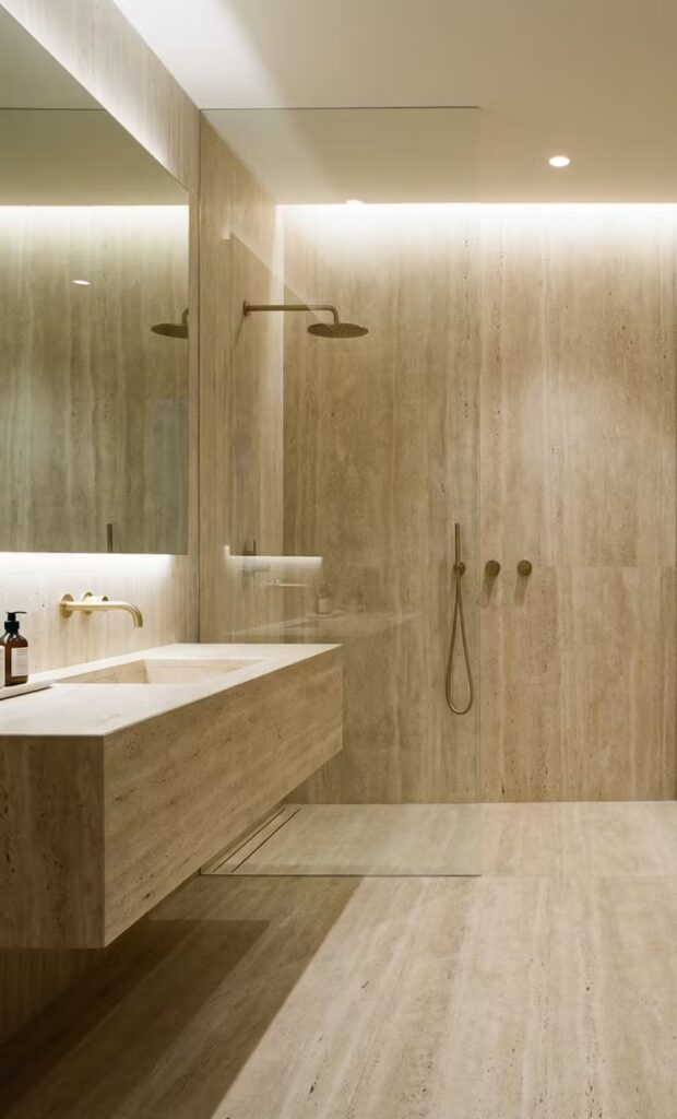 Détail travertin en douche à l’italienne avec pente et siphon